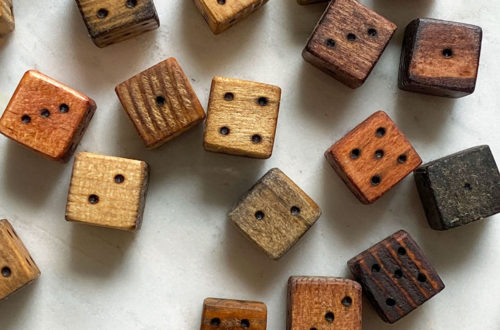 scattering of different colored wood burned dice on a marble table