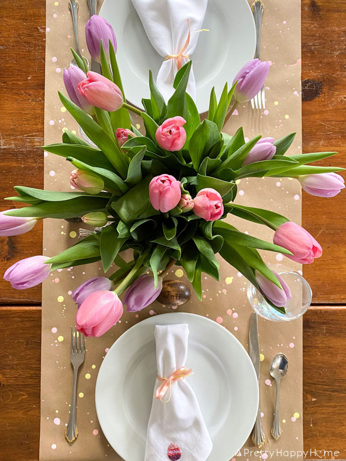 easter table with tulips and embroidered napkin with easter egg on the happy list