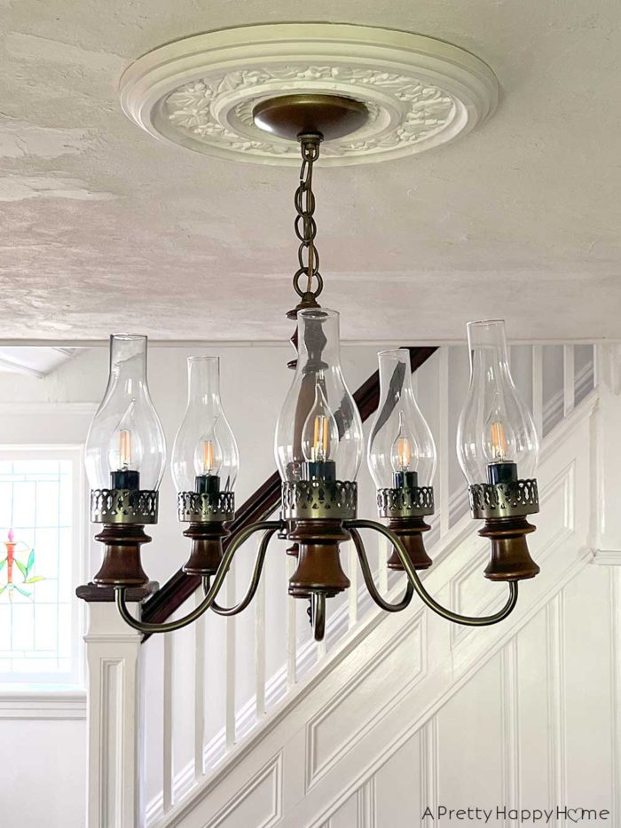 wood chandelier with ceiling medallion in a colonial era home in praise of ceiling medallions