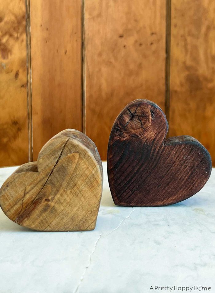 two wood hearts cut out of 2x4s and stained a light color and one, a darker color