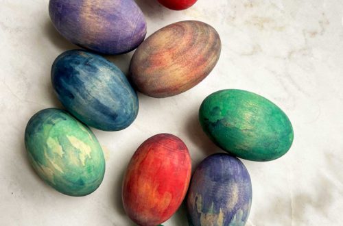 wood easter eggs stained in colorful ways using watercolor paint