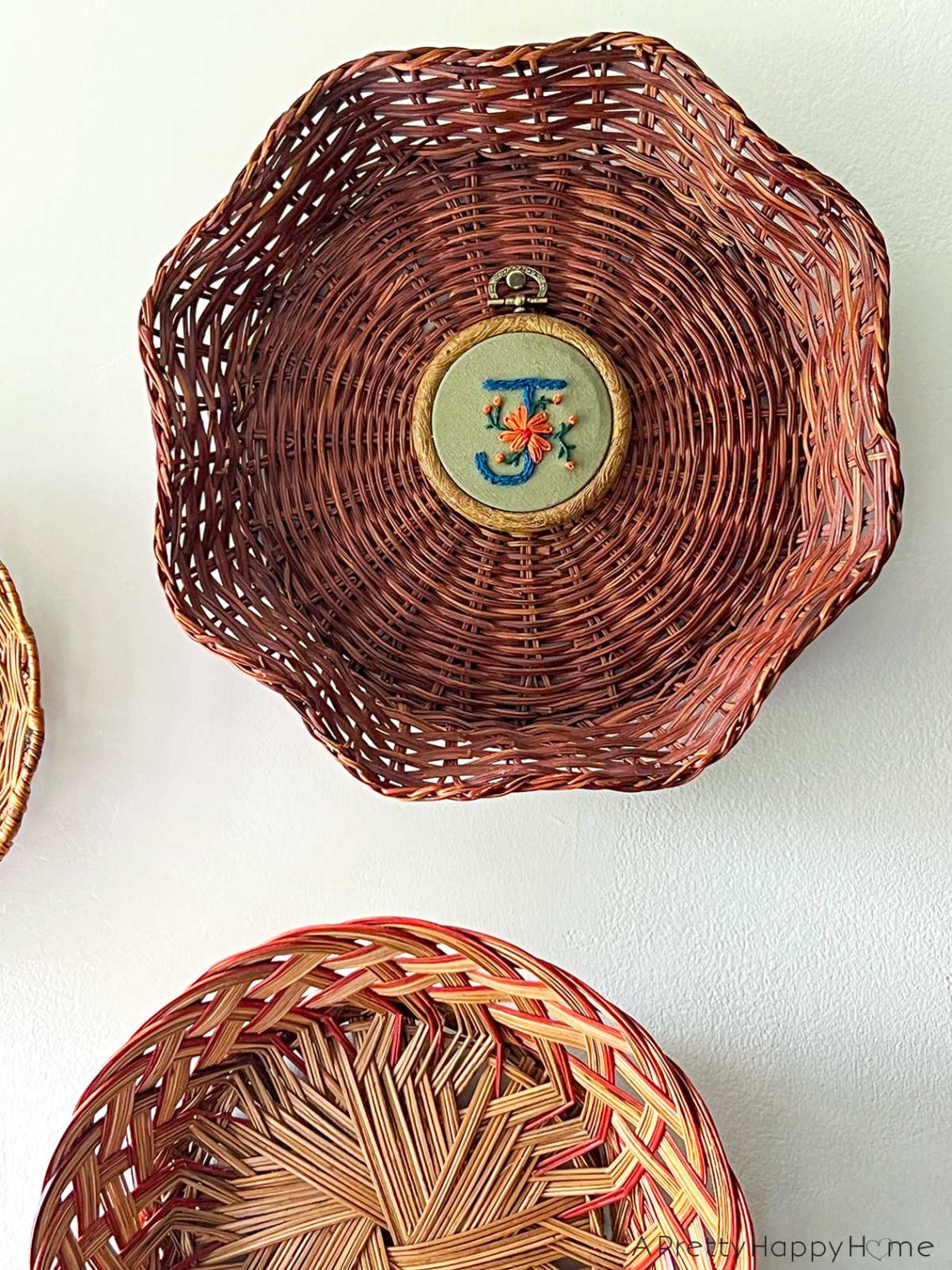 flower monogram embroidery hung in the center of a basket on the wall