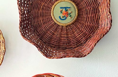 flower monogram embroidery hung in the center of a basket on the wall