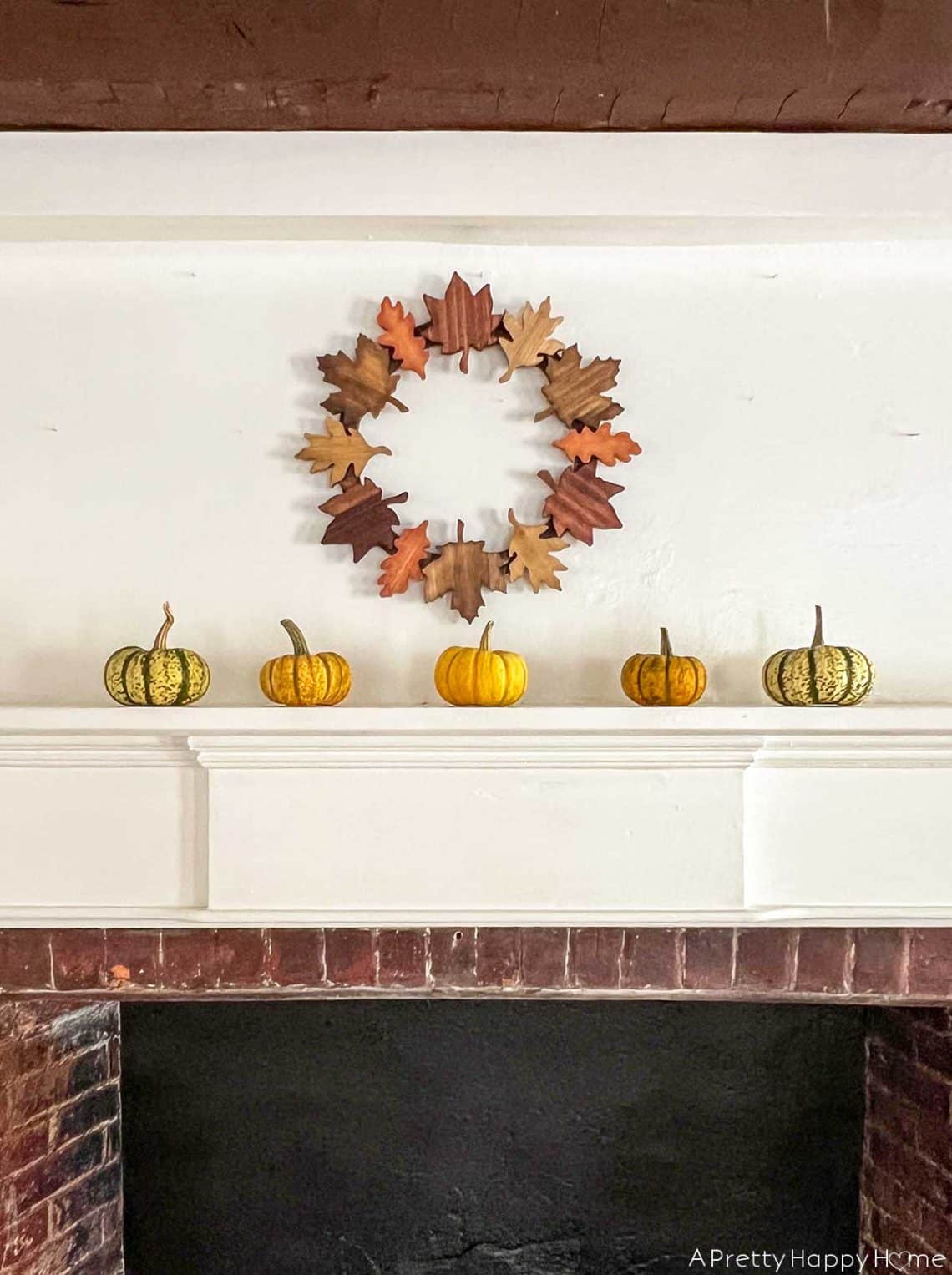 fall mantel with leaf wreath and mini pumpkins on the happy list