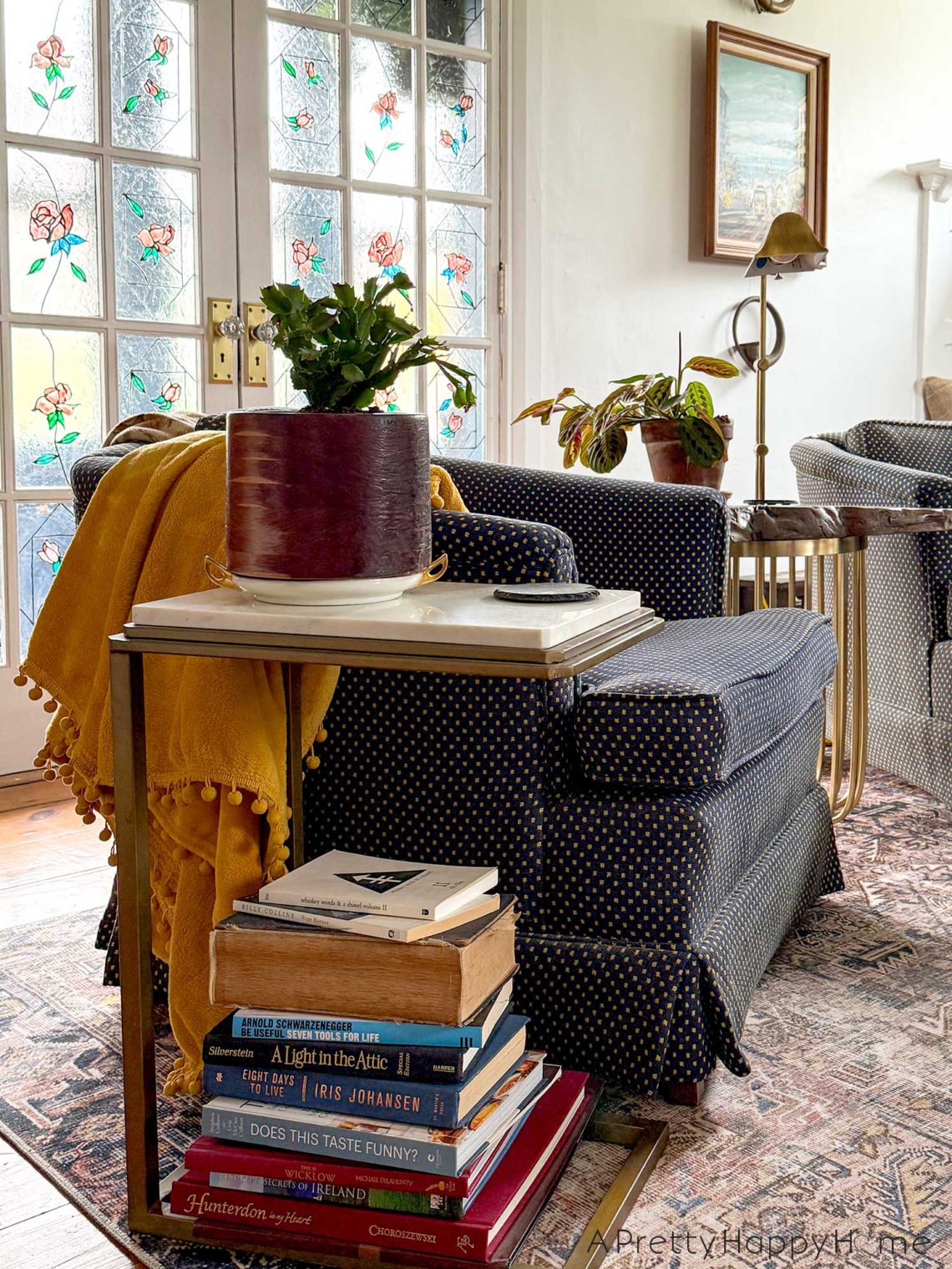 stack of books in a traditional living room with stained glass doors