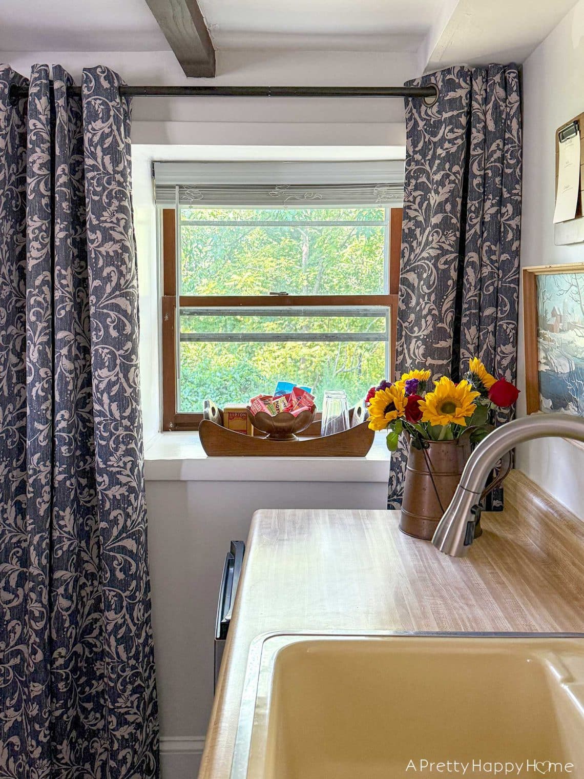 carriage house kitchenette with blue and white curtains to break up long narrow space