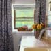 carriage house kitchenette with blue and white curtains to break up long narrow space