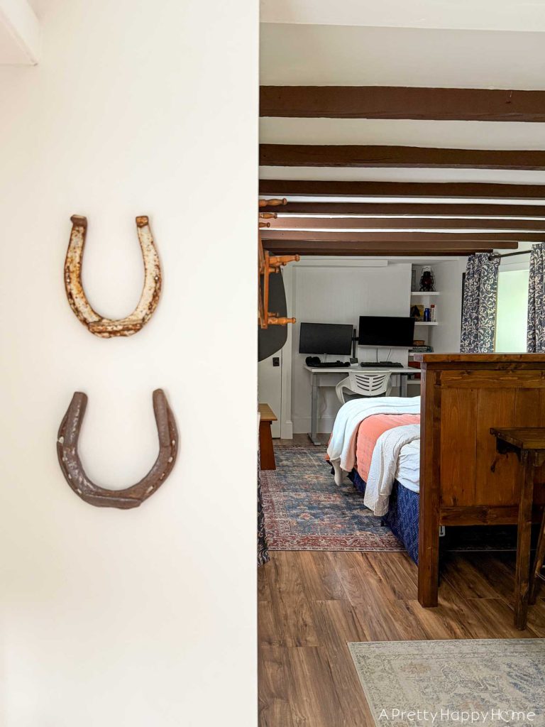blue and white curtains in an old carriage house with wood beams and horseshoe decor