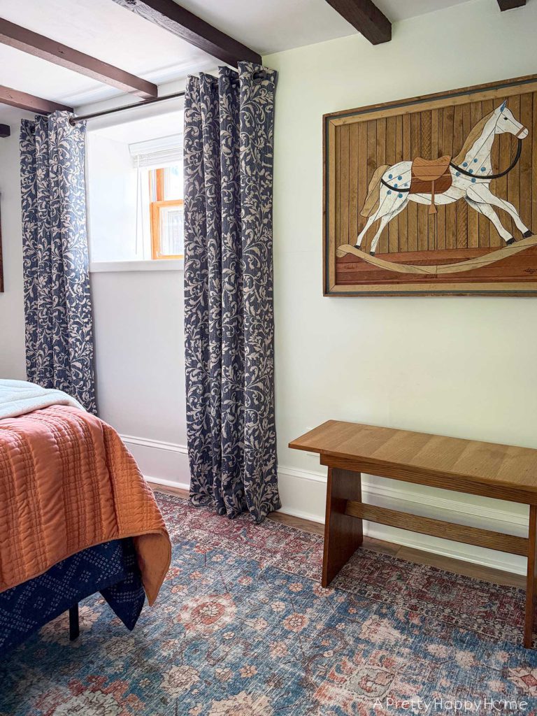 blue and white curtains in an old carriage house with wood ceiling beams