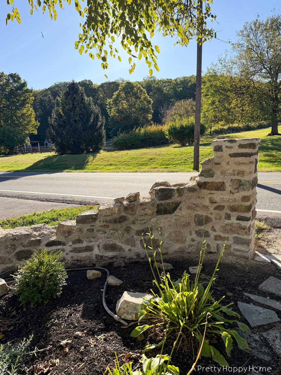 DIY curved fieldstone wall adding a swoop