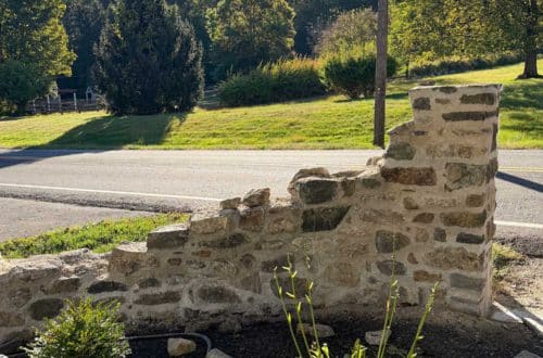 DIY curved fieldstone wall adding a swoop