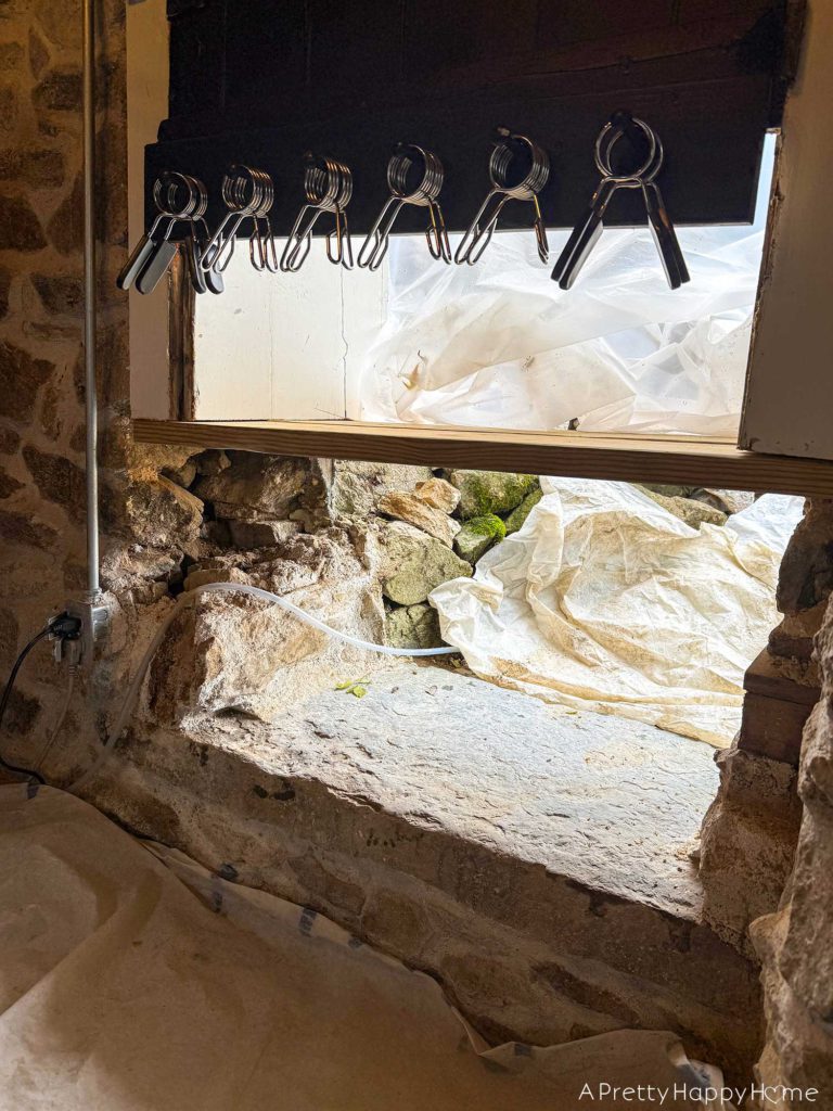 converting a door to a window in a stone building with a stone foundation
