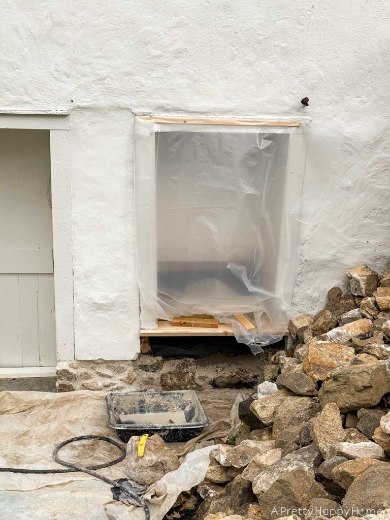 converting a door to a window in a stone building with a stone foundation