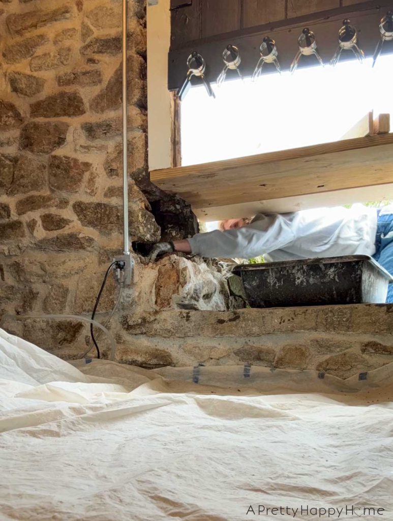 converting a door to a window in a stone building with a stone foundation