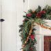 christmas garland with greenery and it is wrapped with a handmade nut garland of in-shell walnuts, almonds, and hazelnuts. the garland is draped over a white fireplace with brick surround and is featured on the blog post five ways to decorate with nuts for christmas