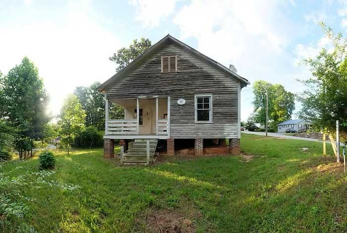 photo of a small dilapidated home with a front porch in Tryon, North Carolina, that was lived in by Nina Simone as a child. The home has now been restored by the National Trust for Historic Preservation. Shown here on the happy list.