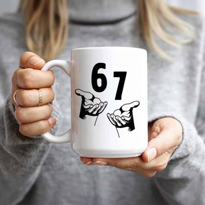 a female holding a white coffee mug with the numbers six and seven in black letters and below that two hands making the eh gesture via amazon on the happy list
