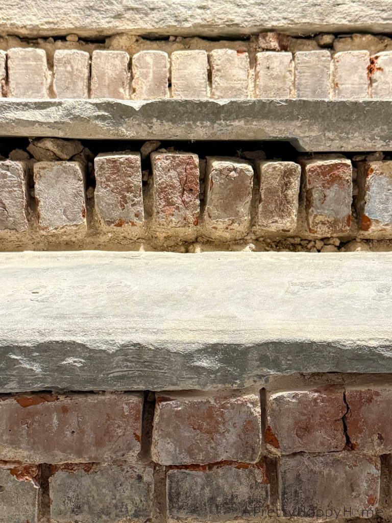 brick risers on flagstone steps that have been chipped out of old mortar making the bricks look like cartoon teeth.