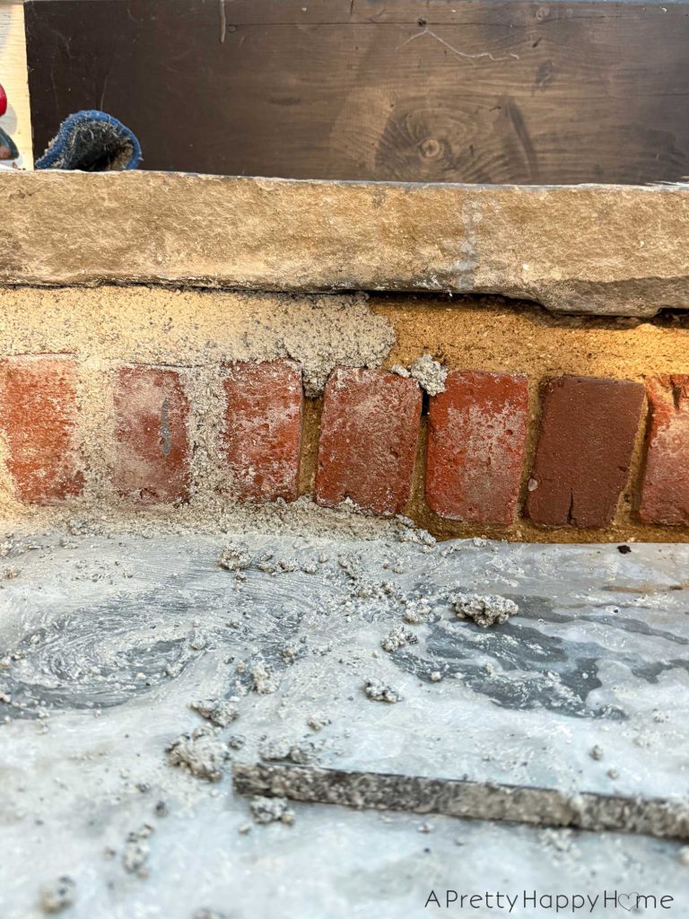 flagstone stairs to a basement with brick risers. the bricks are in the process of being repointed with new lime mortar.