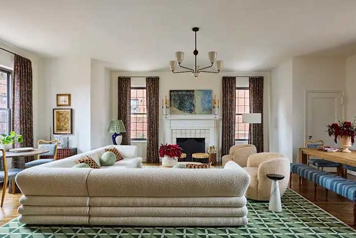 image of a chelsea apartment with tall ceilings, elegant curtains, and a curvy section in cream. Photo taken by Kirsten Francis for Apartment Therapy and shown on the happy list.