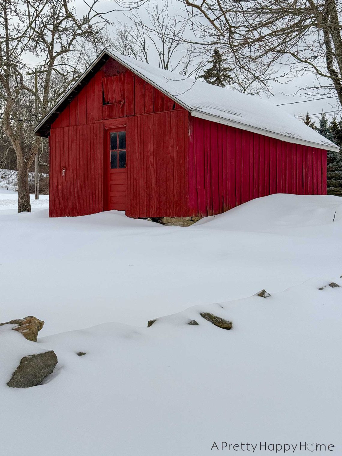 red barn in the snow. there is a door on the end of the door with a glass window.
