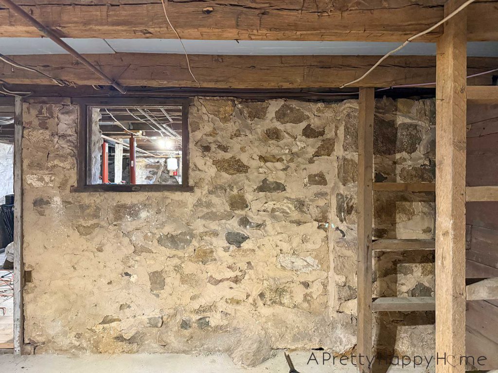 picture of a basement workshop stone repointing project showing a stone foundation wall that needs to be repointed with new lime mortar