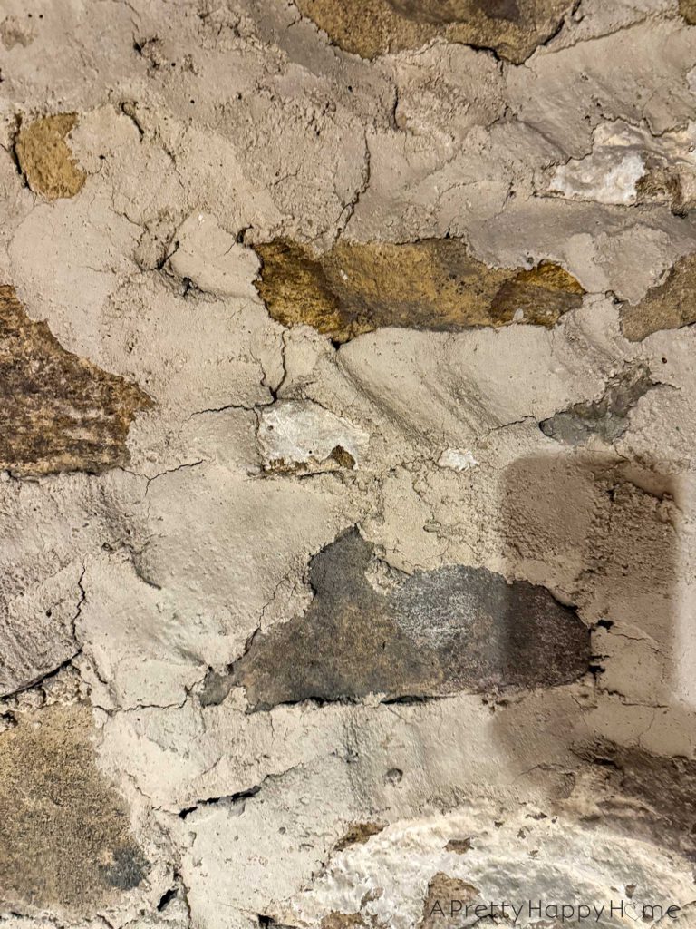 picture of a basement workshop stone repointing project showing a stone foundation wall that needs to be repointed with new lime mortar