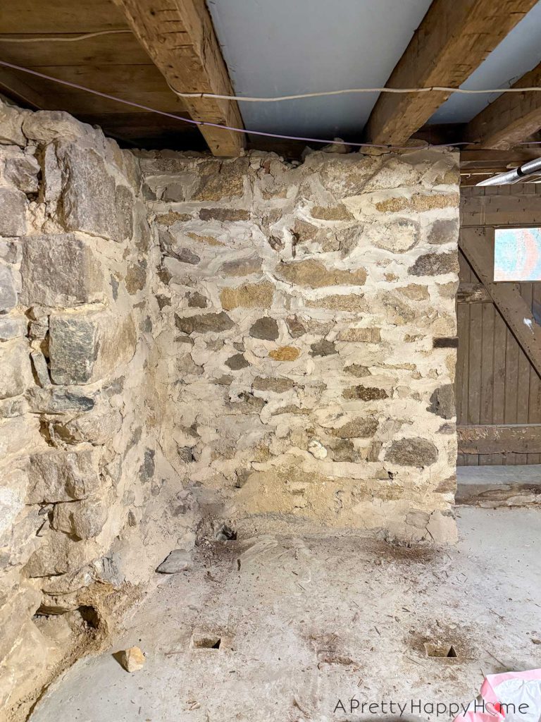 picture of a basement workshop stone repointing project showing a stone foundation wall that needs to be repointed with new lime mortar