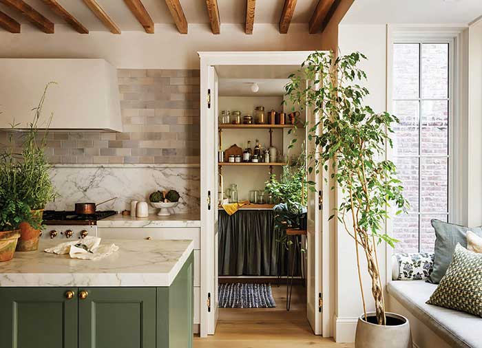 Behind the La Cornue range in the kitchen of a 19th-century Brooklyn carriage house designed by Britt and Damian Zunino of Studio DB, a backsplash of white Calacatta marble gives way to a grid of BDDW handmade ceramic tiles. photo by MATTHEW WILLIAMS via frederic magazine