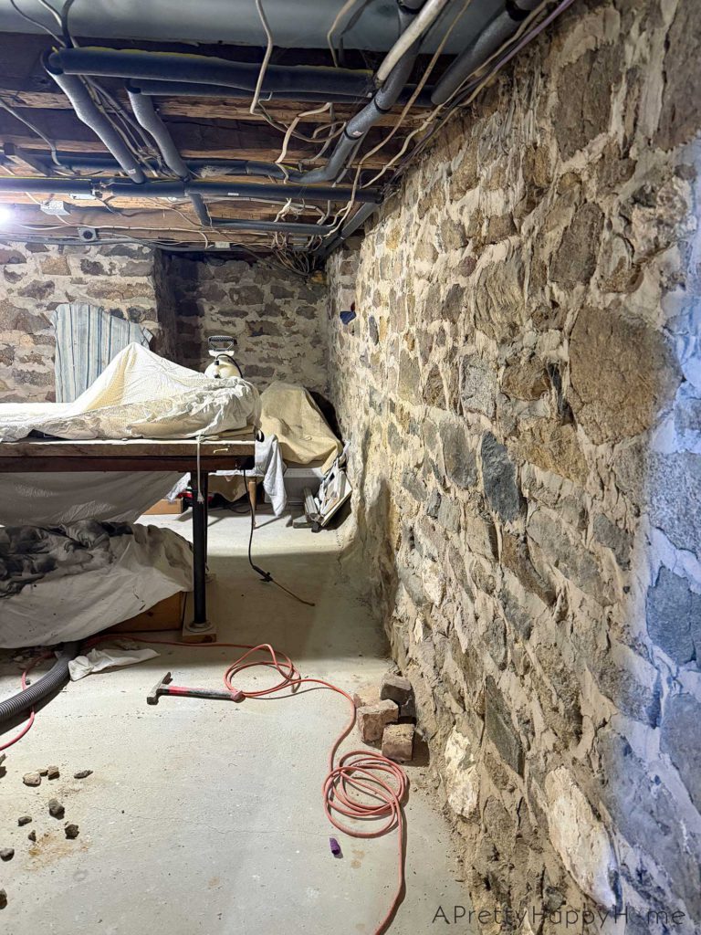 stone foundation from the 1780s chipped out to be repointed with new lime mortar. Photo shows spot at the base of the foundation wall that had been covered in concrete that was trapping moisture in the wall.