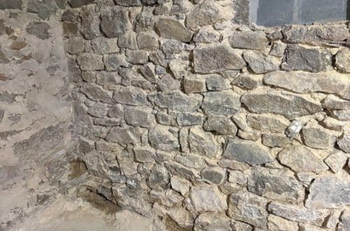 stone foundation from the 1780s being chipped out and repointed with new lime mortar made from natural hydraulic lime