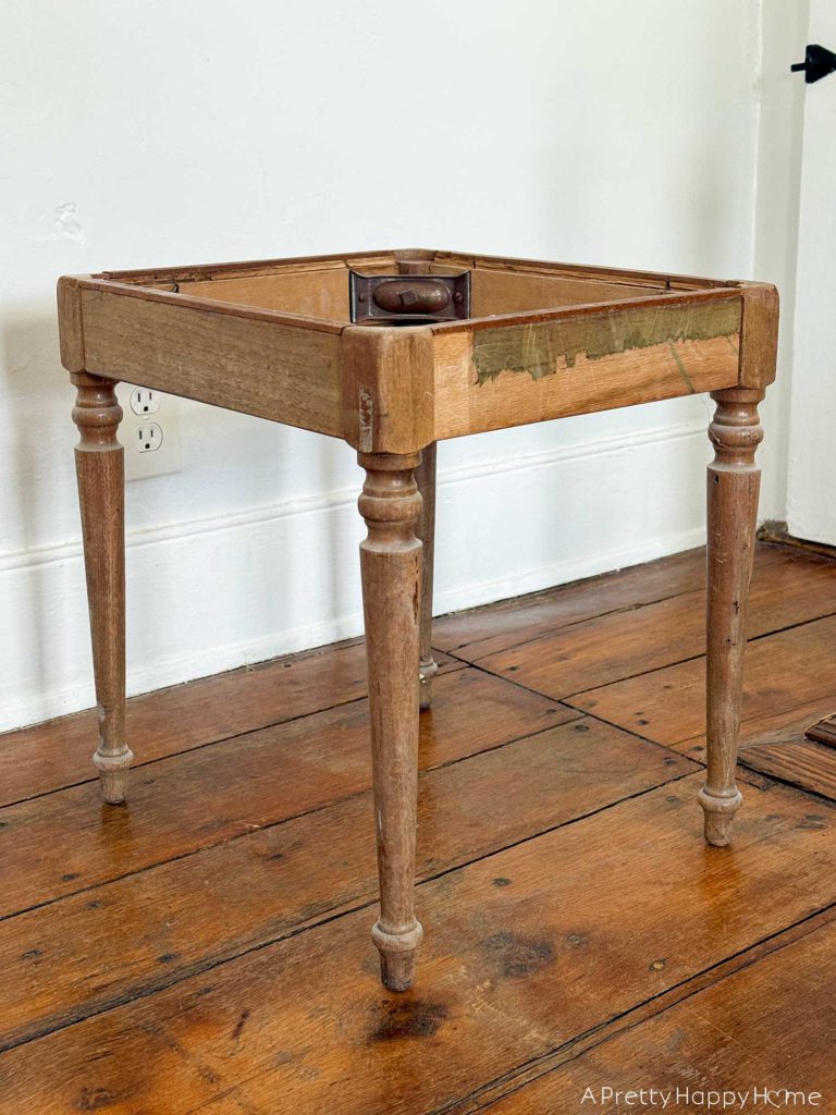 wood base of an upholstered stool ready to be sanded and stained for a makeover.