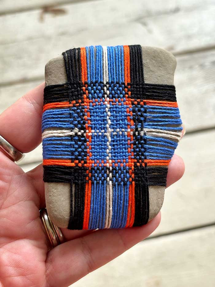 colorful string woven on a rock by Curious Crone