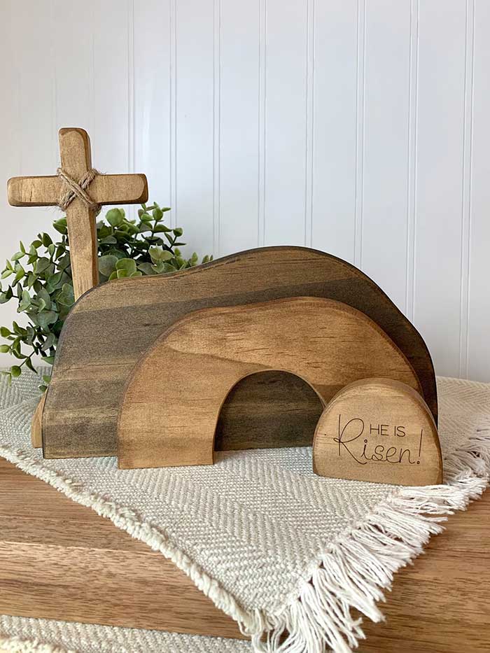 wood empty tomb display for easter featuring 3 wood cutouts in different stains that resemble a cave and a wood cross from etsy shop glory oaks