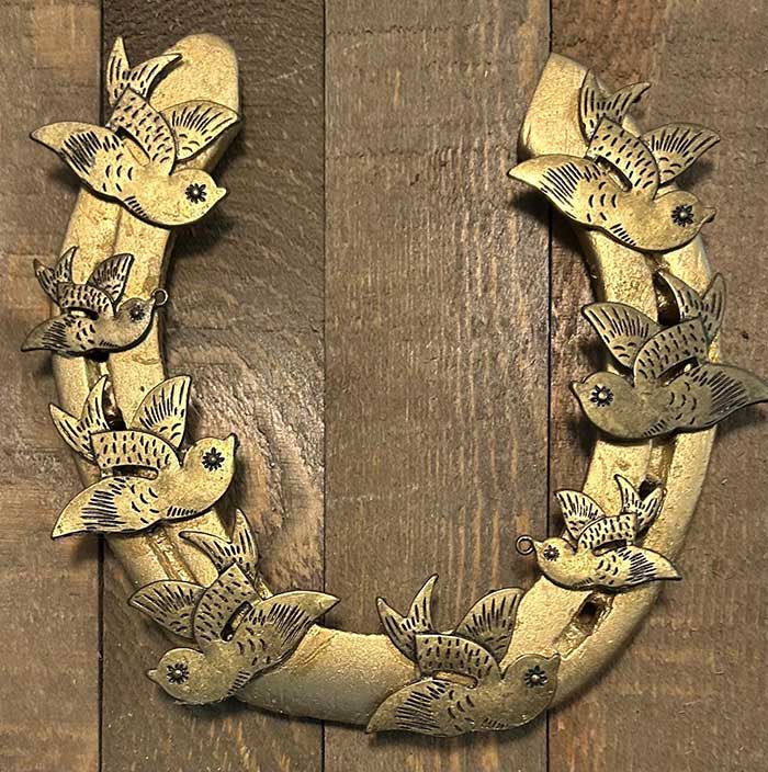 horseshoe painted antique gold and embellished with small metal birds also in gold from etsy shop gallopandgarlann