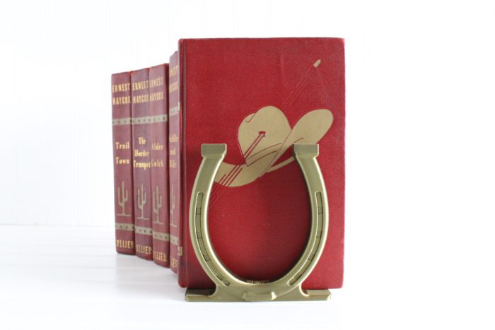 gold horseshoe bookend on a stack of red books by etsy shop delightfullydutch