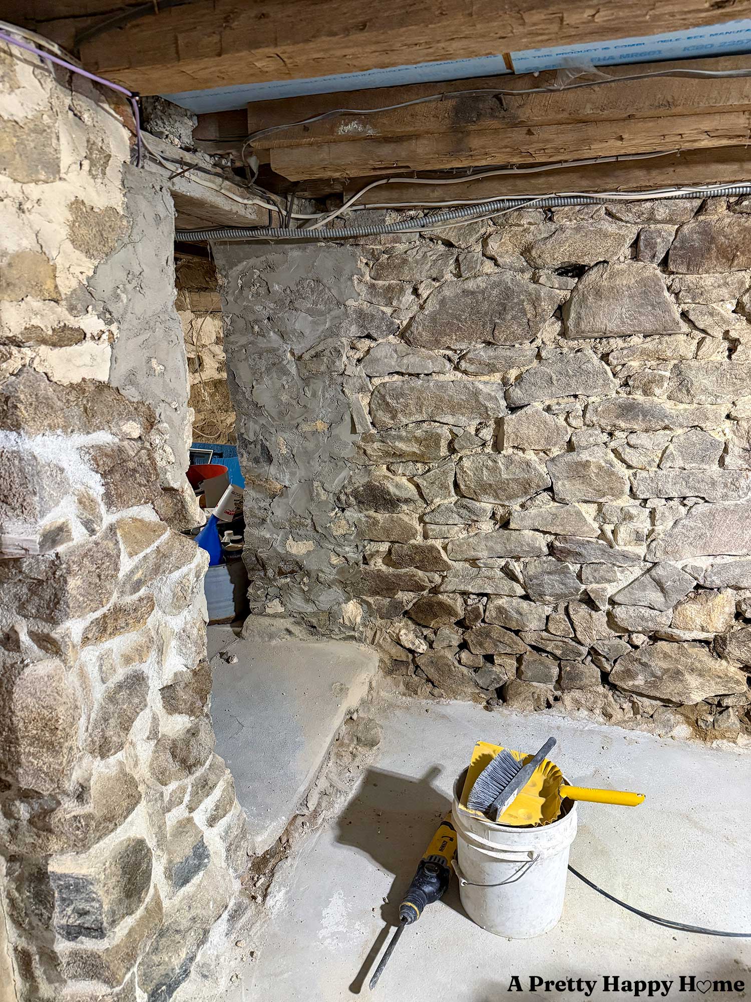 stone foundation in a 1780s home showing a poorly constructed opening to an addition. The opening is secured with concrete over the lime mortar and is not supporting the floor joists well.
