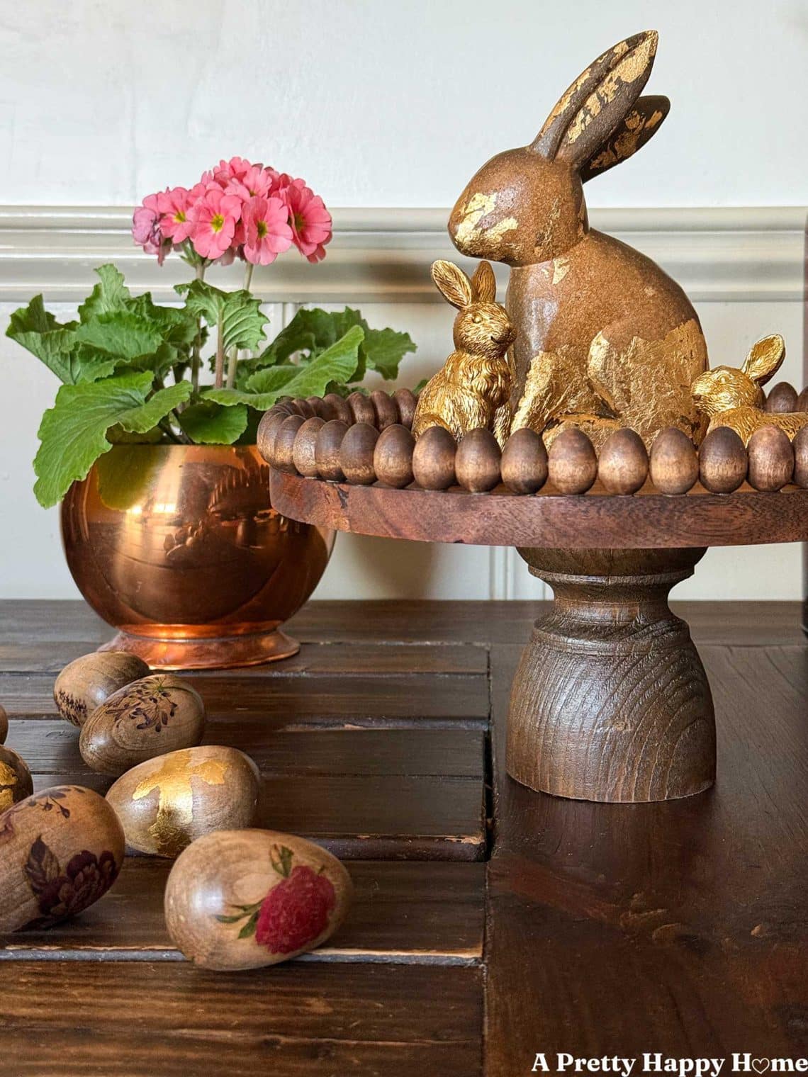 DIY wood pedestal or cake stand trimmed for Easter with mini wood eggs that are glued around the edge of the stand