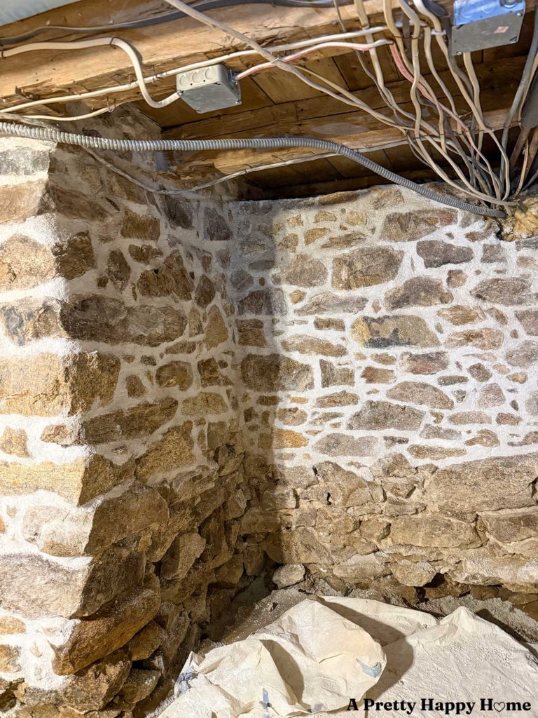 an interior stone foundation wall in the process of being repointed, the top of which was unstable and was rebuilt