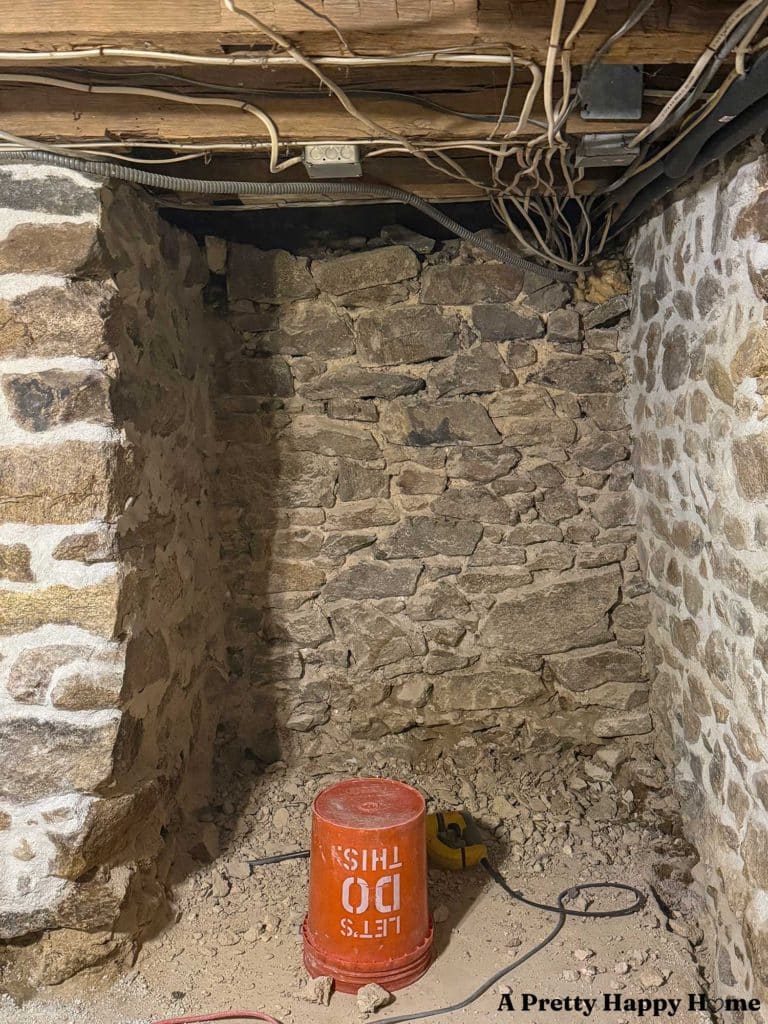 an interior stone foundation wall in the process of being repointed, the top of which is unstable and needs to be rebuilt