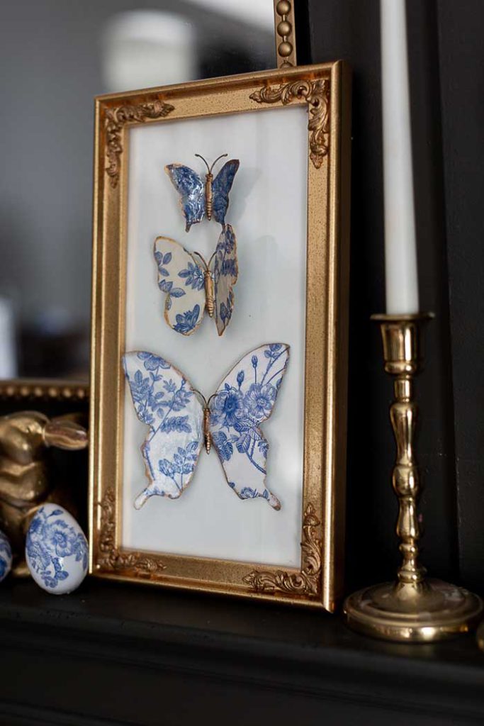 blue and white chinoiserie ceramic butterfly specimen art in a gold frame. Made from dollar store materials by Craftberry Bush blog.