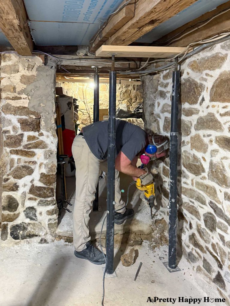 chipping up the concrete floor in the basement of a 1780s home to reveal the base of an old foundation wall