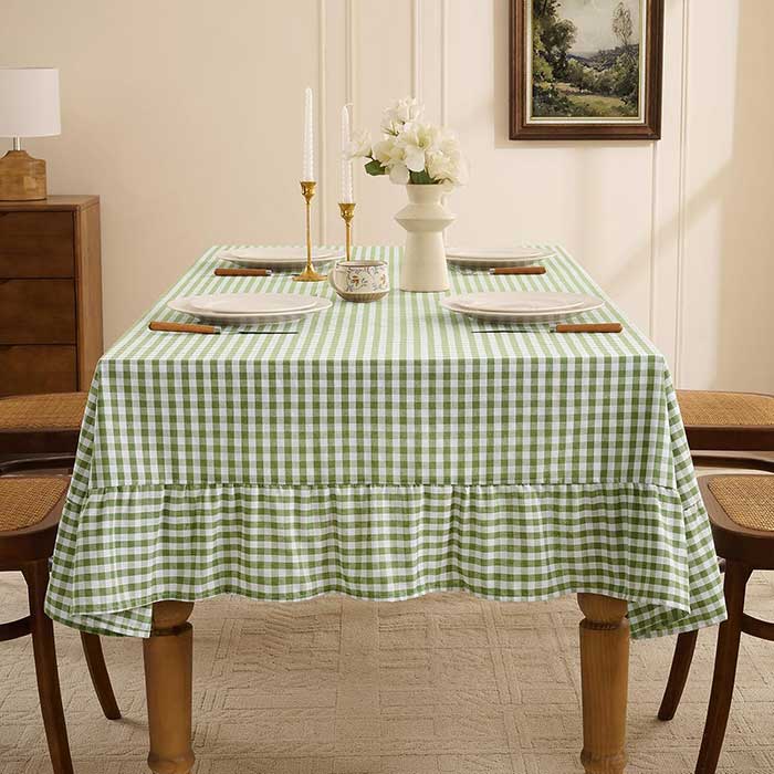green and white ruffled gingham tablecloth on a wood table in a simple farmhouse setting