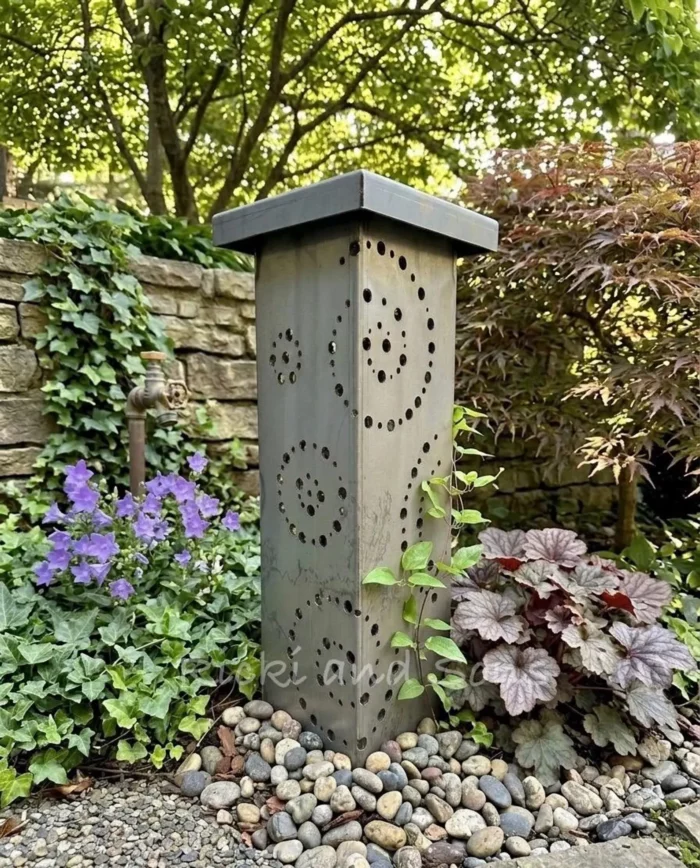 garden column with circular cutouts in a garden setting. it's designed to cover a well head and has solar lights by RickiandSonsShop on Etsy