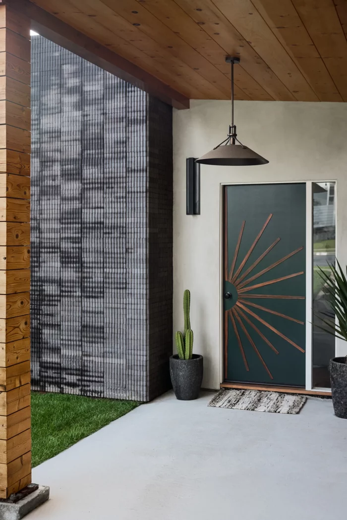 front door on a mid century home that is black with a wood starburst pattern made with thin strips of wood photo by tina michelle and featured in sunset