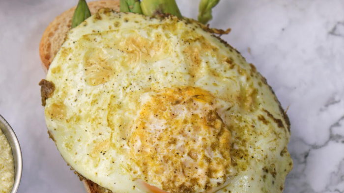 award-winning pesto asparagus on toast recipe with an egg on top. photo by sam jones of vaughn communications via almanac.com