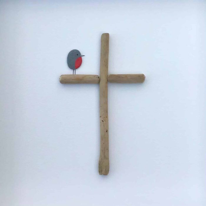 art featuring a robin made out of a small pebble sitting on a cross made of driftwood