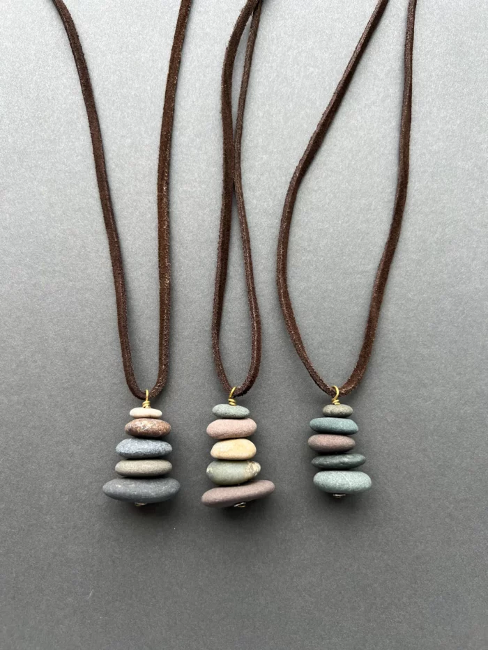 3 necklaces made of stacked stones from lake michigan and hung on leather cords via etsy shop generosity company