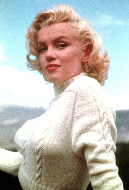 Marilyn Monroe circa 1953 wearing a white sweater with her iconic blond hair and red lipstick