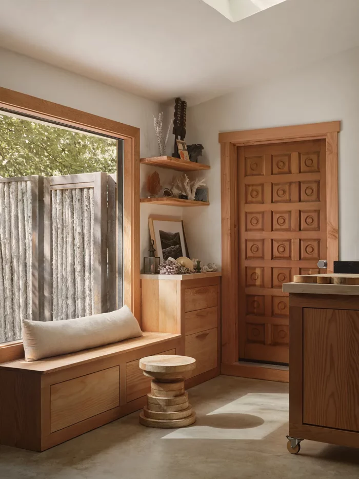 homes with wood bench and doors featuring a wood side table made of wood rounds stacked in varying sizes.